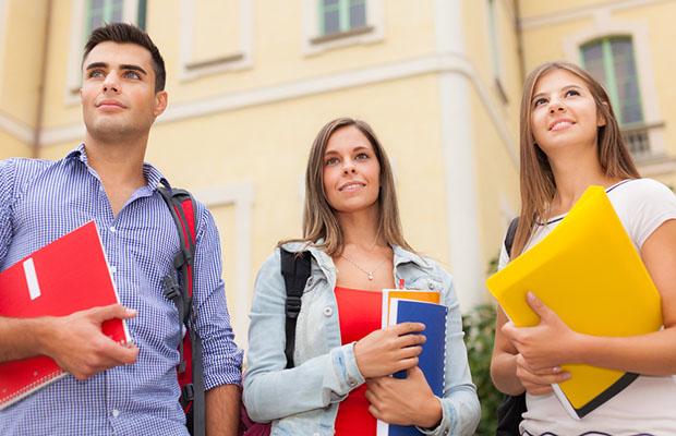 three college students holding folders and books